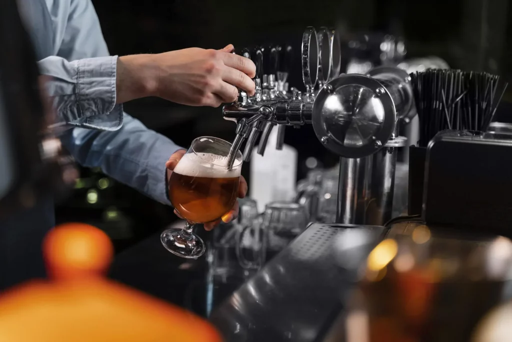 Close up of bar staff pouring beer from a tap